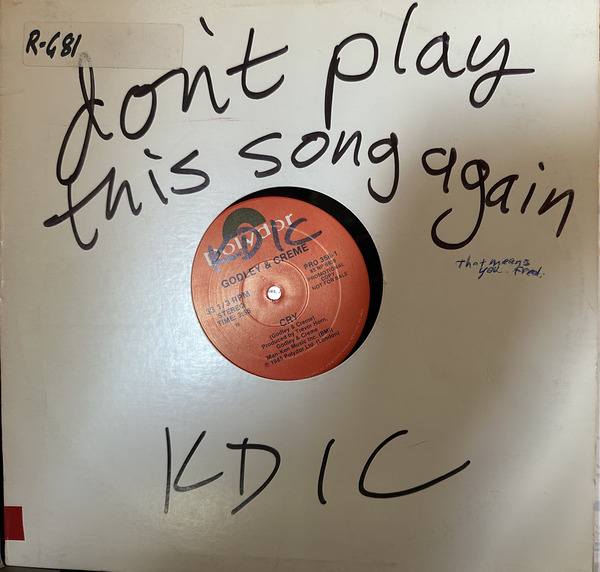 A white record cover with the words 'don't play this song again' written on the front in large letters. The cover also says 'This means you Fred' in smaller letters. And there's a big, hand-written 'KDIC'. The record label indicates that it's the song 'Cry' by Godley and Creme