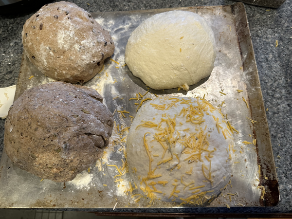 Four piles of dough. The two on the left are darker, the two on the right are lighter.