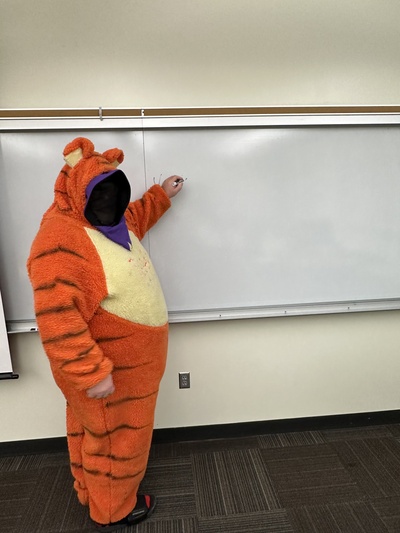 Sam in a Tigger sit with a hidden face.